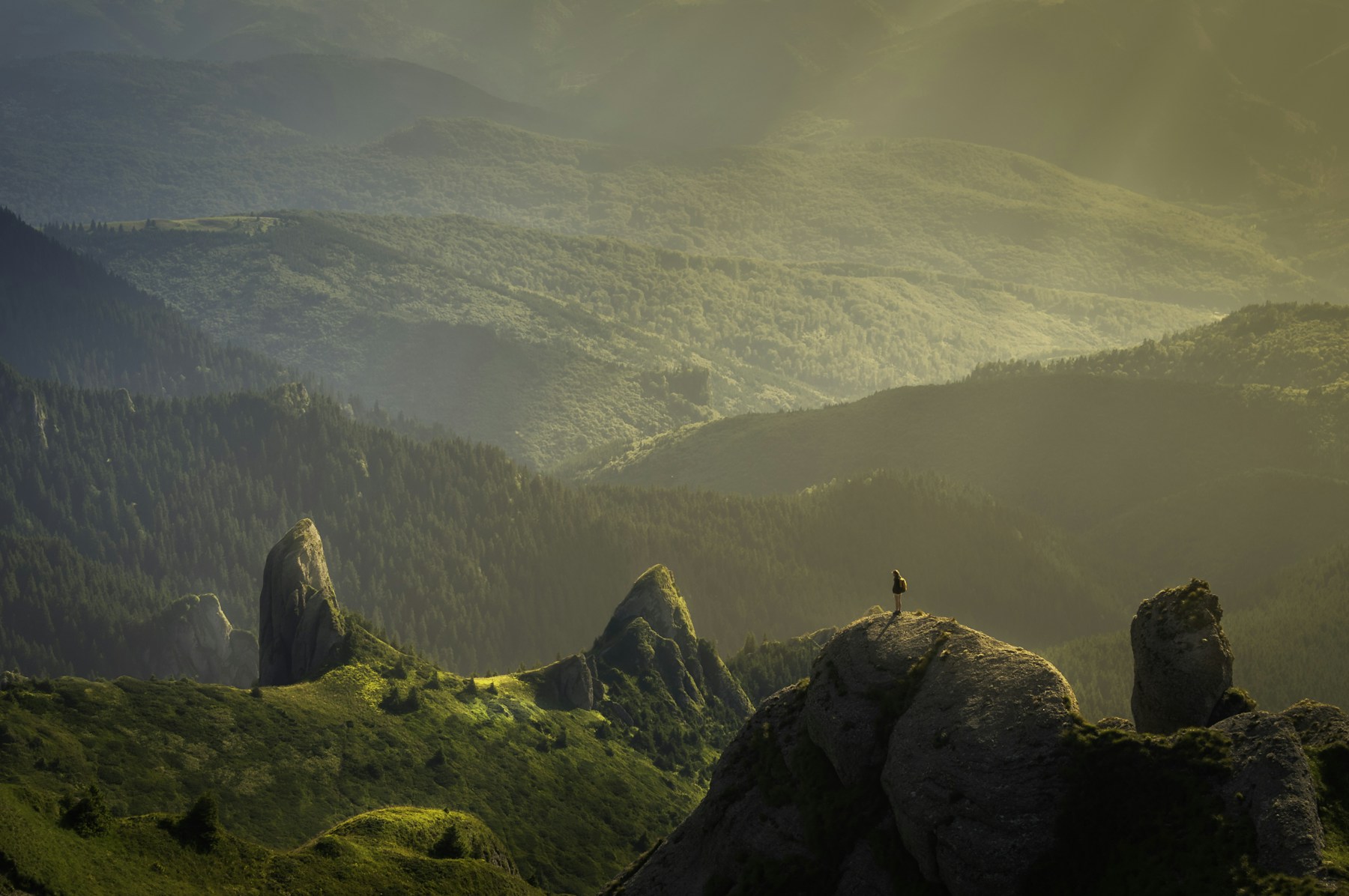 Man hiking through a vast mountain landscape
